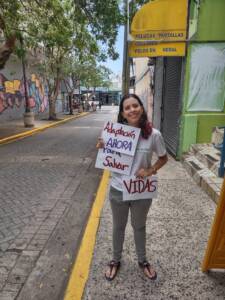 Earth Day photo petition by CCN Member in Puerto Rico. A young woman is holding a sign which reads 'Adaptación ahora para salvar vidas' (Adapt Now to Save Lives in English)..