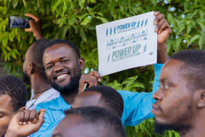 A participant at the training workshop held in Haiti holding up a 'Power Up' sign